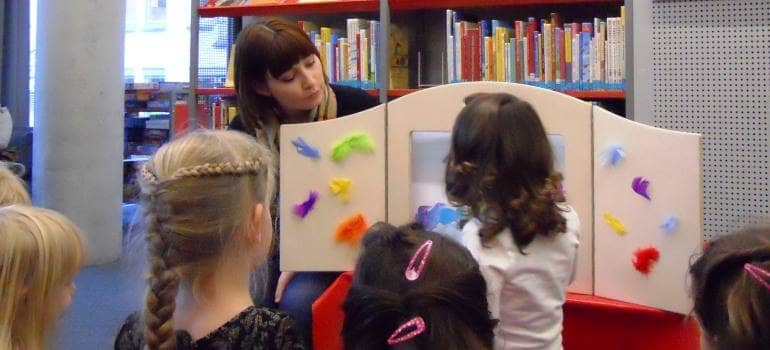 Kinderbibliothekarin zeigt Kindern ein Kamsihibai