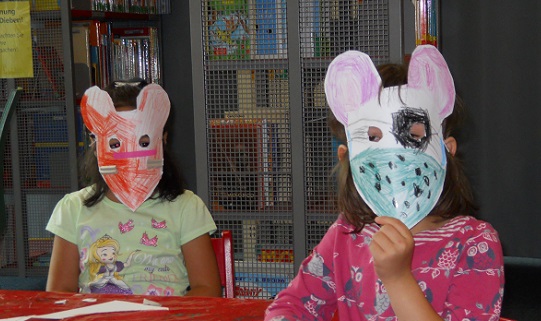 Zwei Kinder mit einer selbst gebastelten Maske