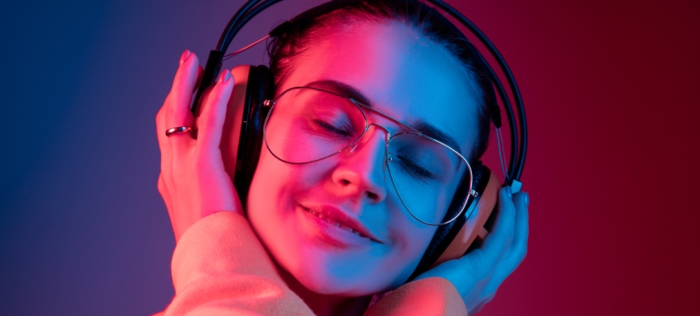Junge Frau,  die über Kopfhörer Musik hört